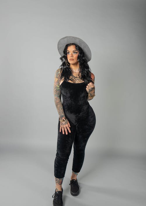 A Woman Wearing Black Jumpsuit and Gray Hat with Arm Tattoo