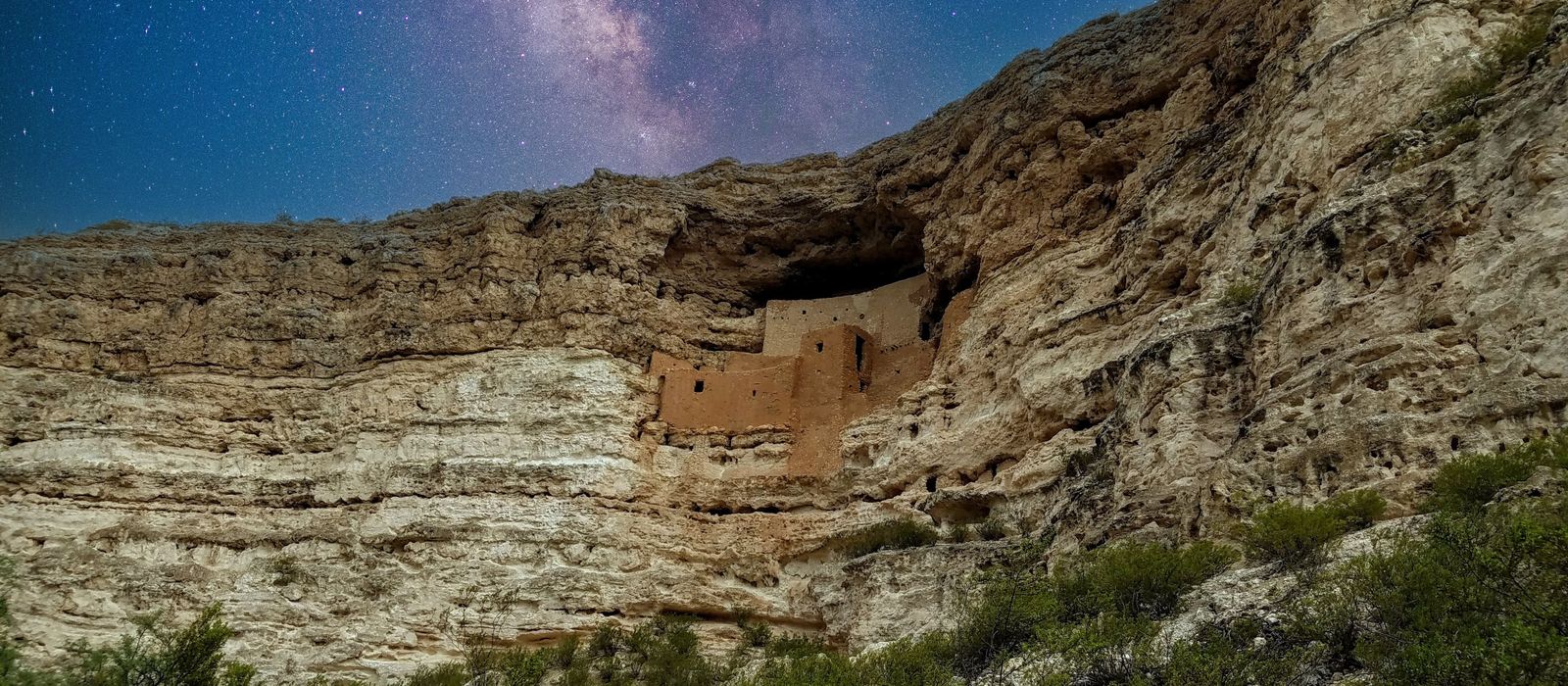 Montezuma Castle amidst a starlit sky in Camp Verde, AZ, showcasing ancient cliff dwellings.