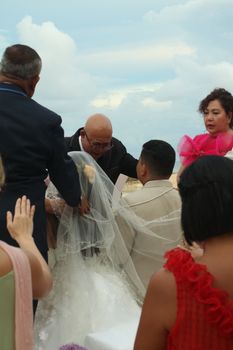 An intimate outdoor wedding ceremony with guests gathered around the bride and groom. - Fotografer Sidoarjo