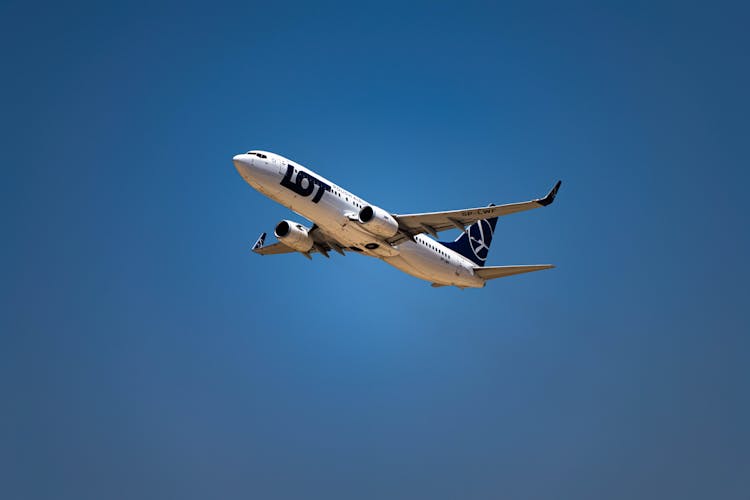 A Flying Airplane Under The Blue Sky