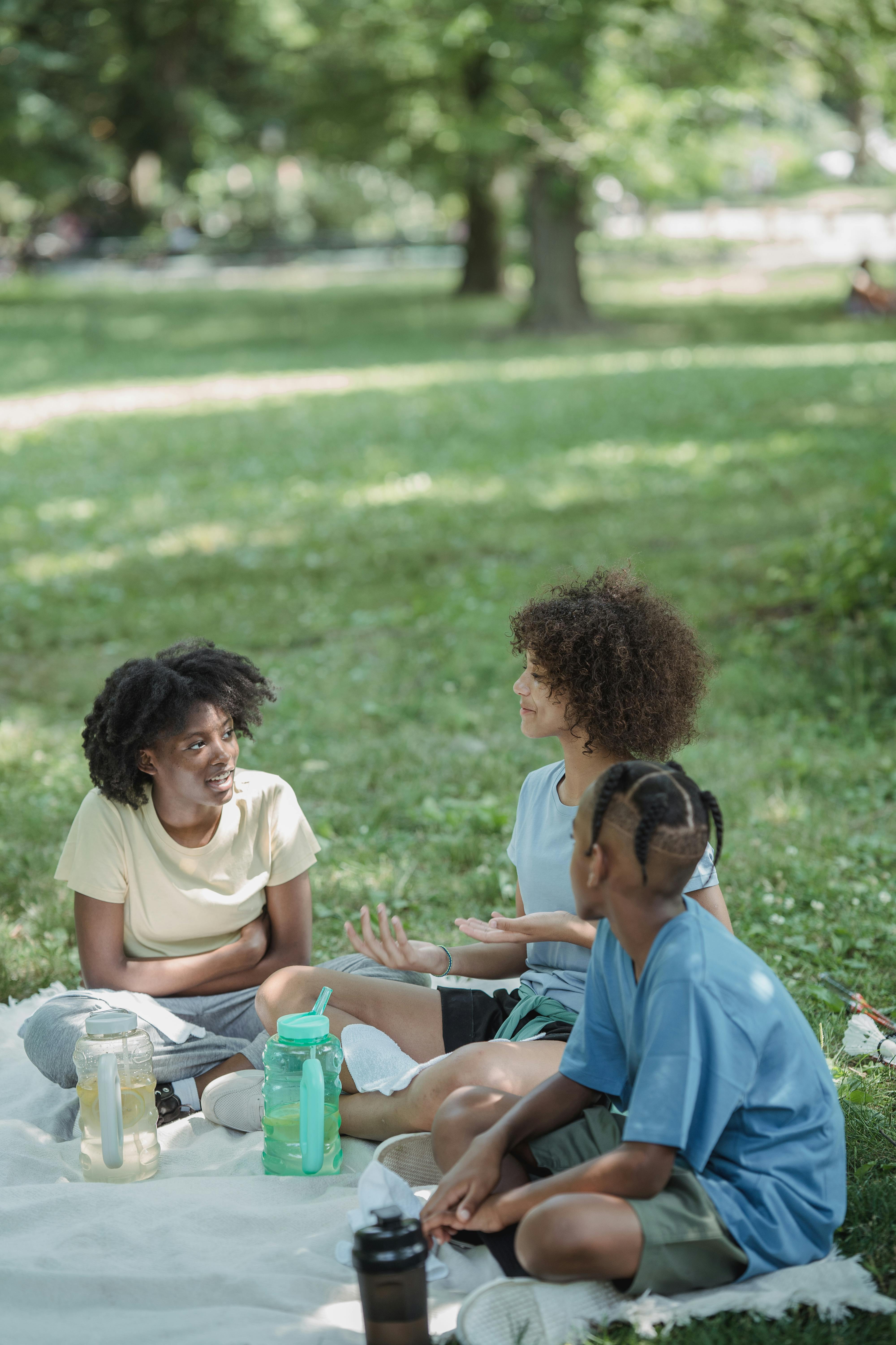 friends sitting on a blanket in the park