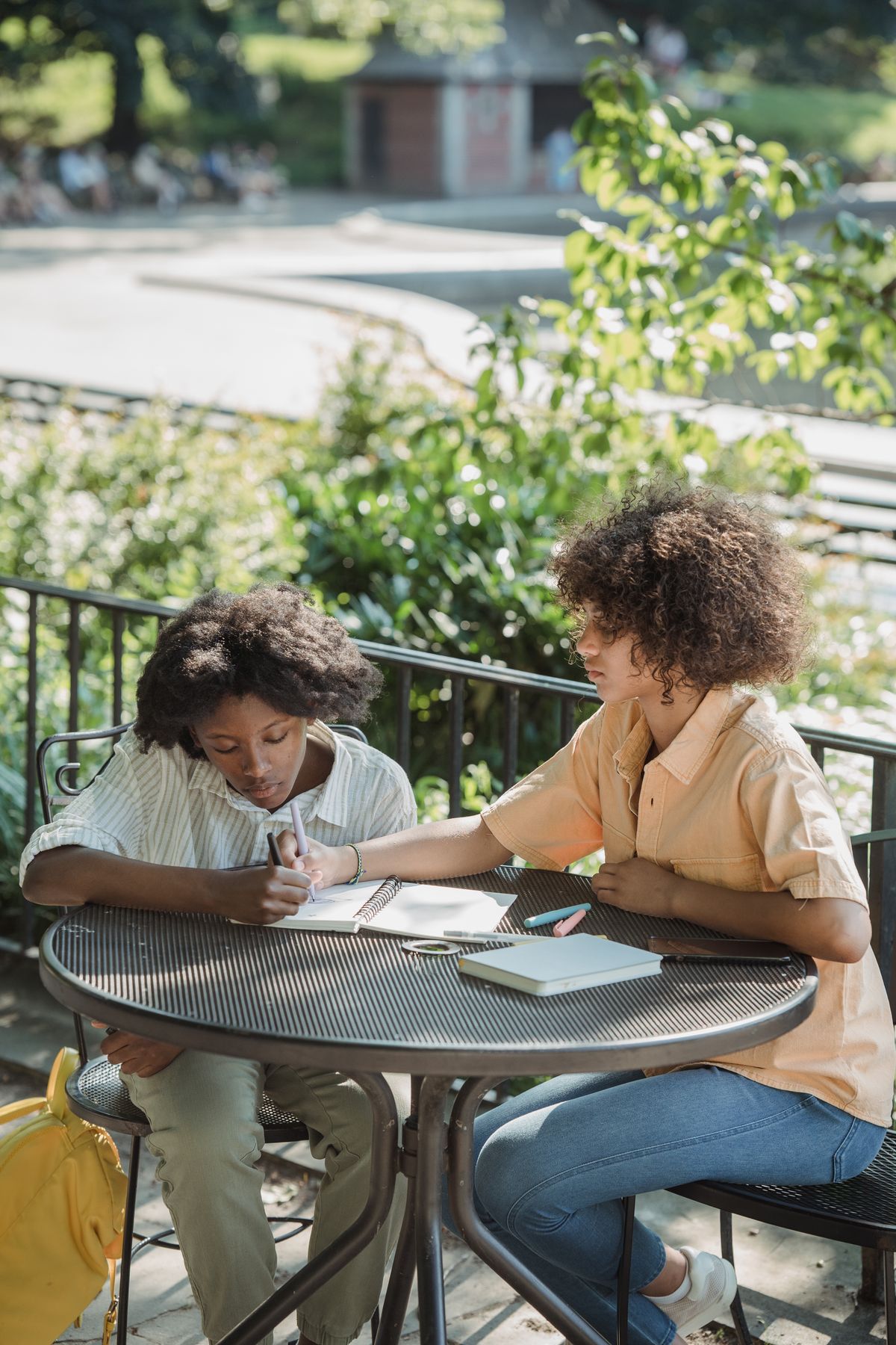 A young person writing in a guided journal beside a warm cup of herbal tea