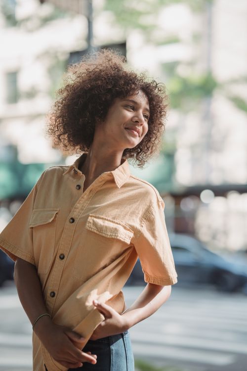 Free Happy African American teenager posing joyfully outdoors in an urban setting. Stock Photo