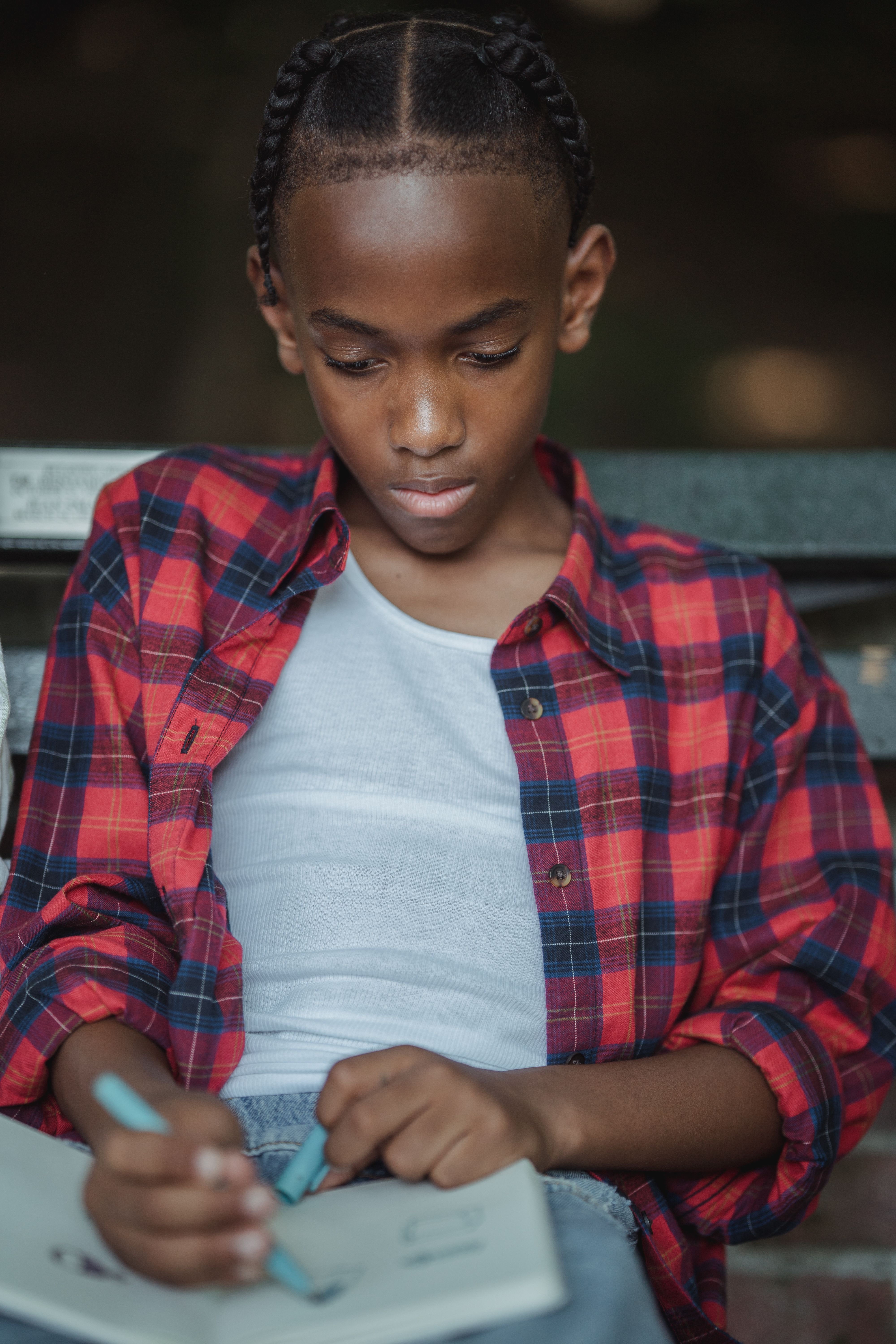A Boy Drawing in a Notebook · Free Stock Photo
