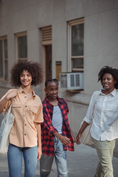 Free Three friends enjoying a walk in the city, exuding happiness and friendship. Stock Photo