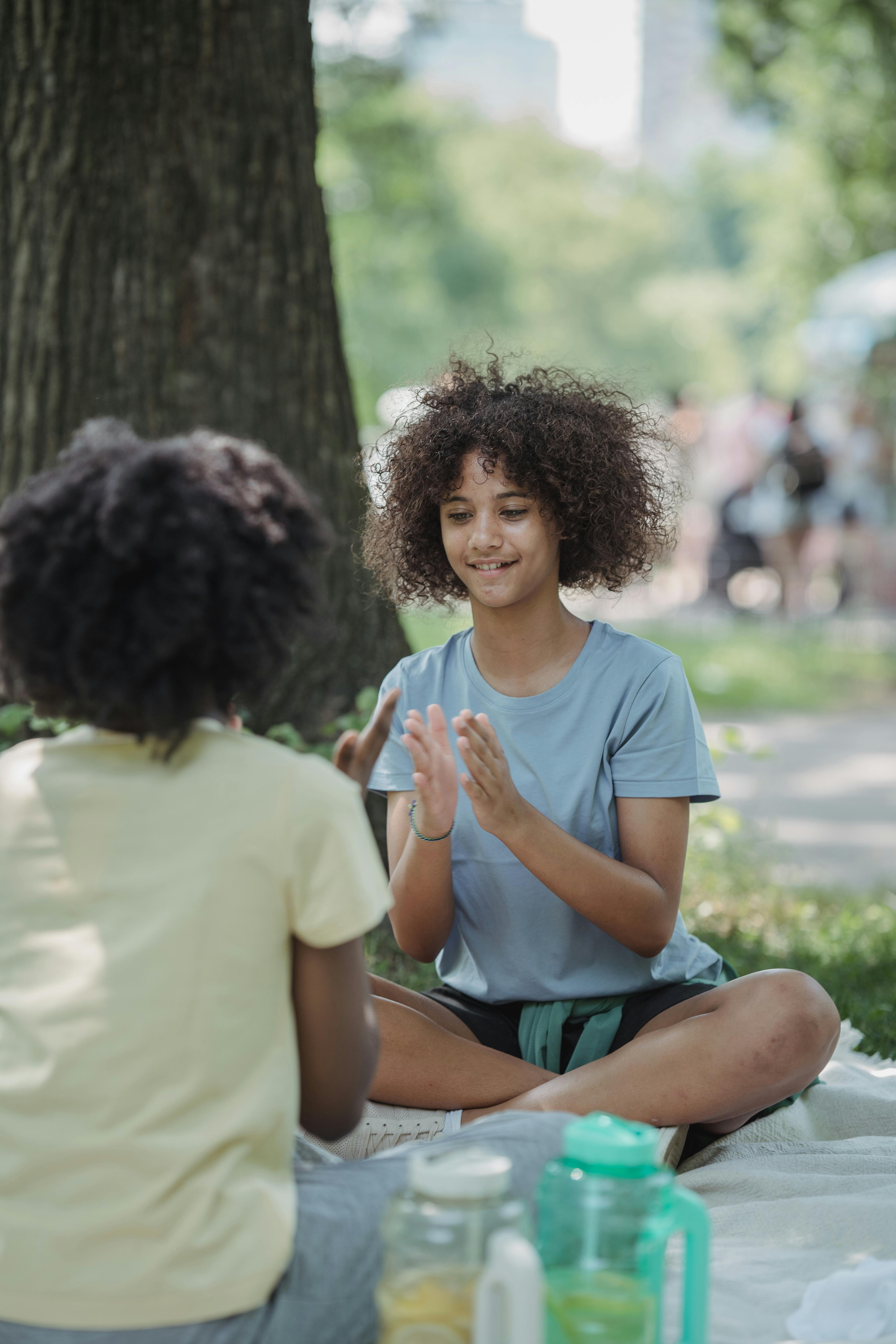 Teenage Girls Playing Patty Cake during Picnic in a Park · Free Stock Photo