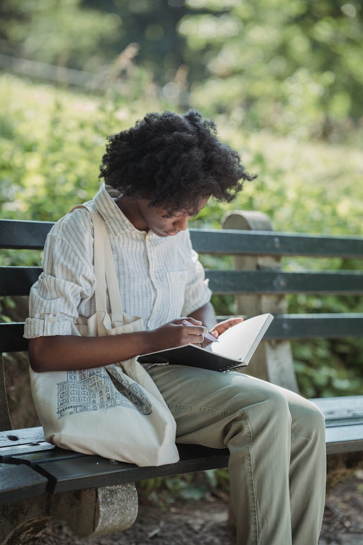 Woman Sitting On A Bench And Reading A Book 