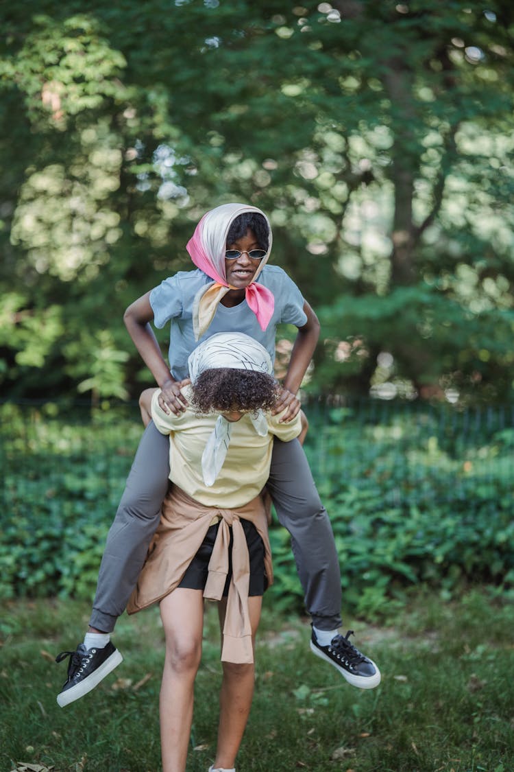 Teenage Girl Carrying Her Friend On Her Back 