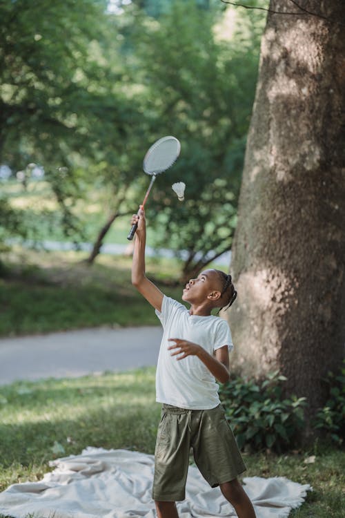 Young Boy Playing Badminton Outdoors 