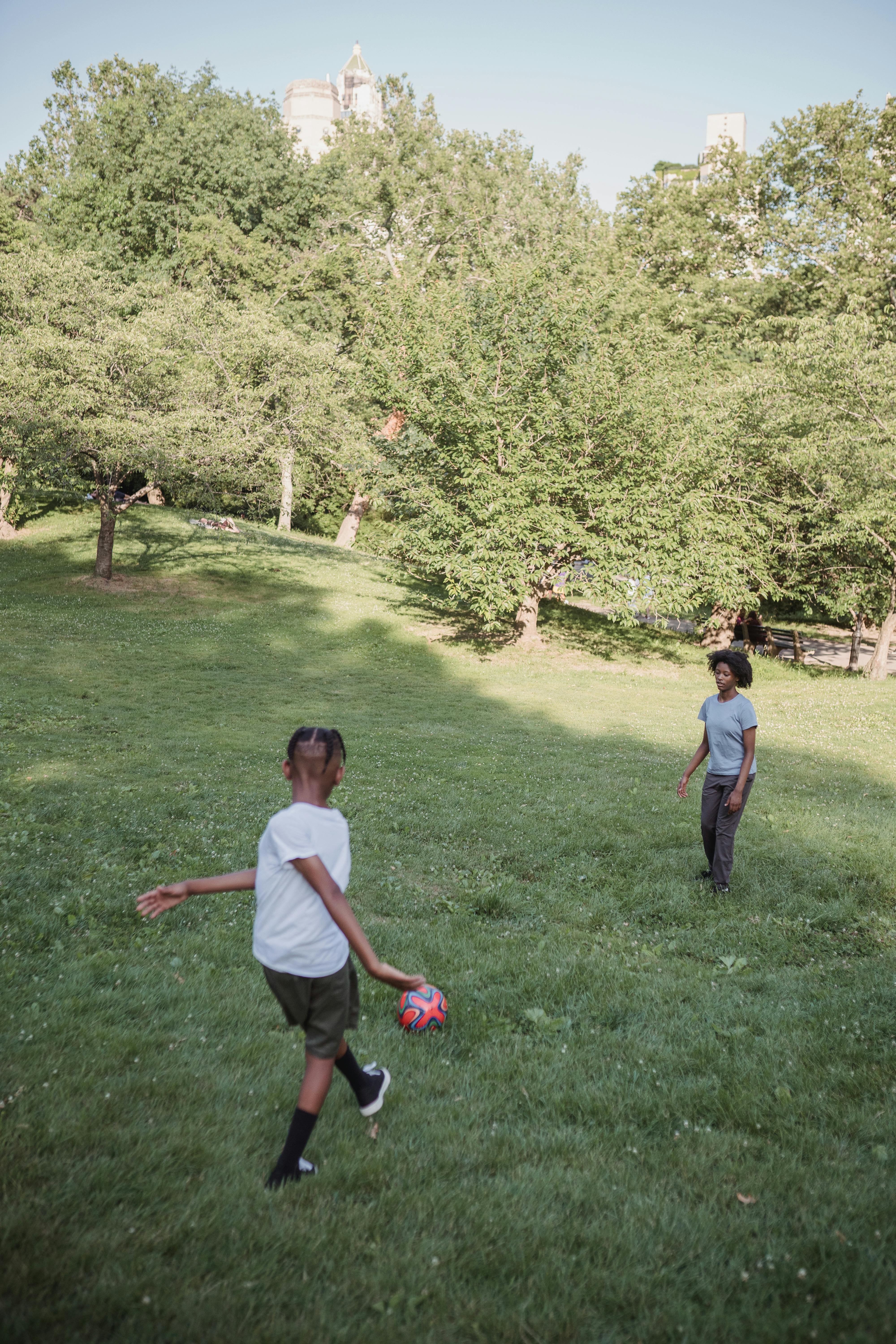 kid playing football with a teenage girl