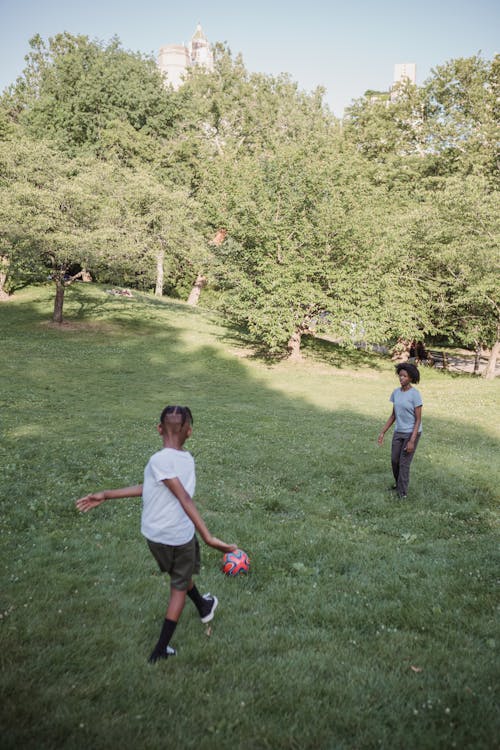 Kid Playing Football with a Teenage Girl 