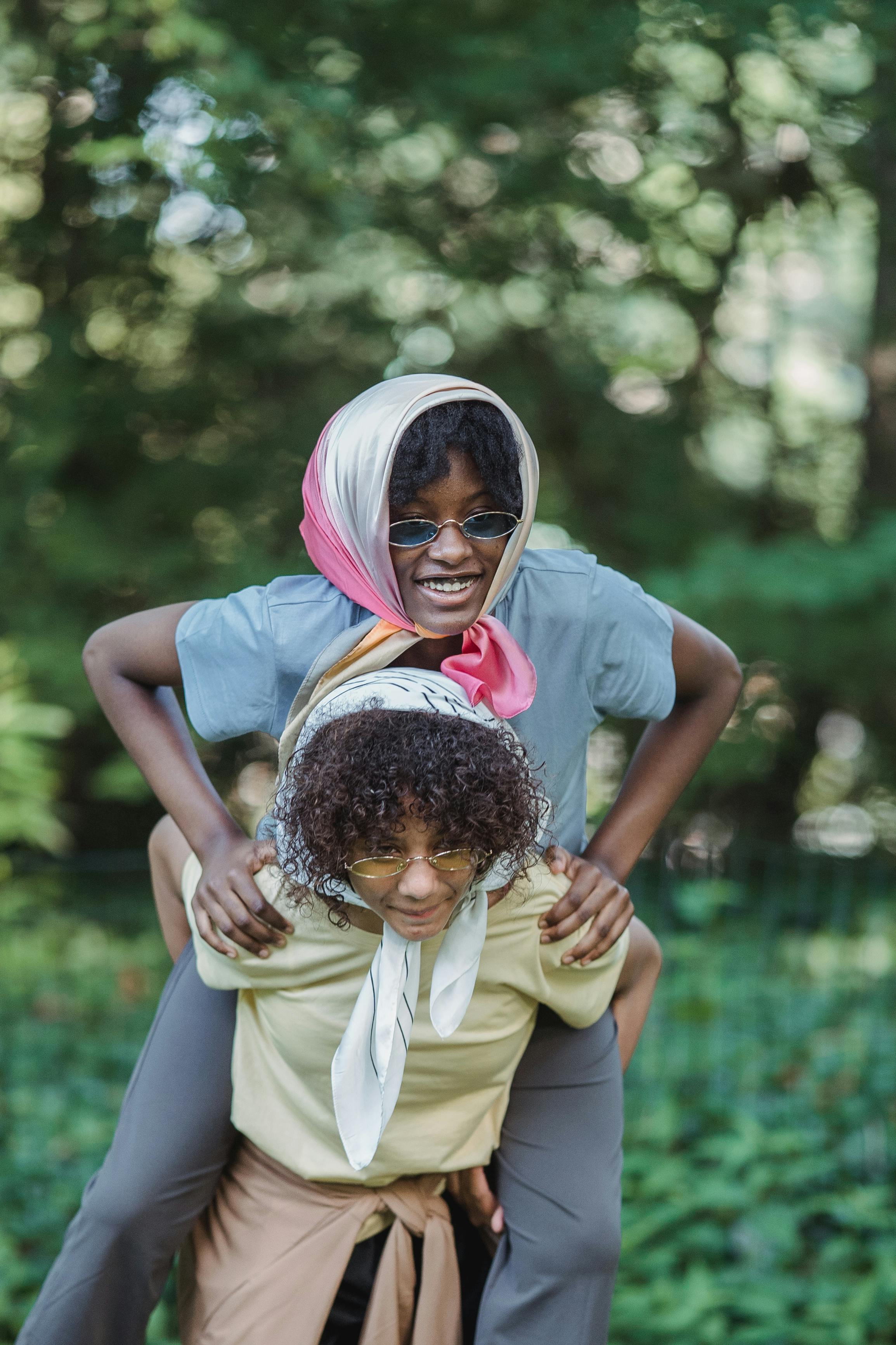 teenage girl carrying her friend on her back