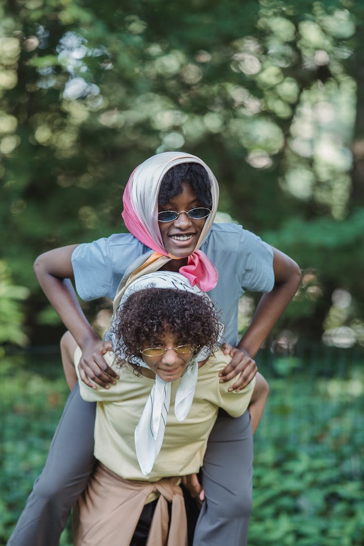 Teenage Girl Carrying Her Friend On Her Back 