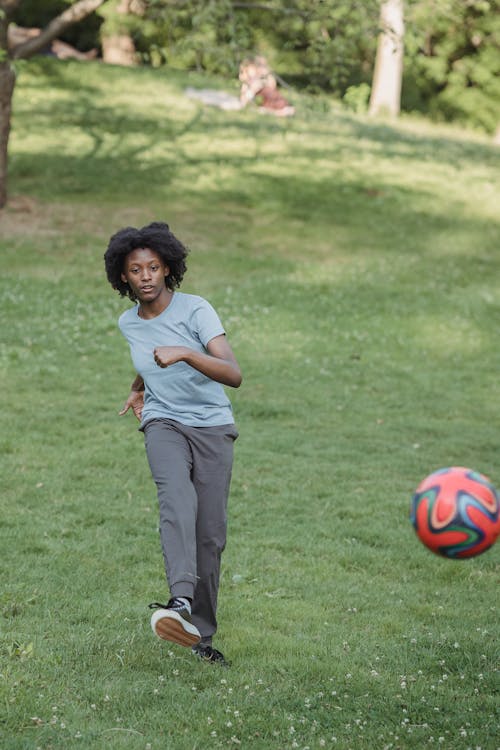 Young Woman Kicking a Football Ball 