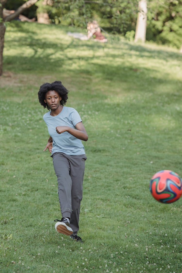 Young Woman Kicking A Football Ball 