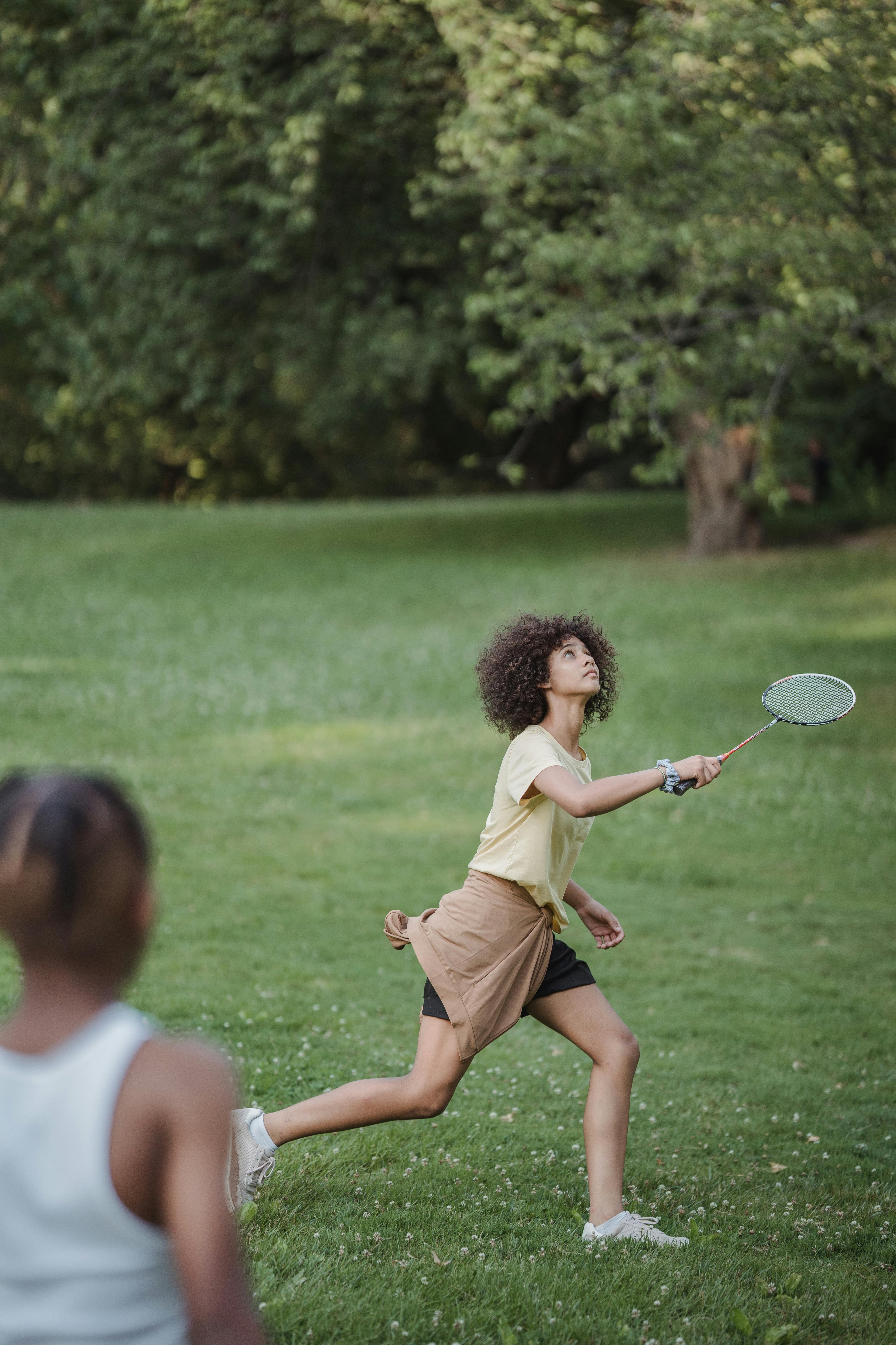young people playing badminton outdoors