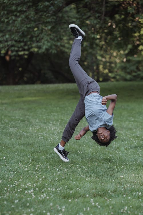 Girl Making a Cartwheel on Lawn in a Park