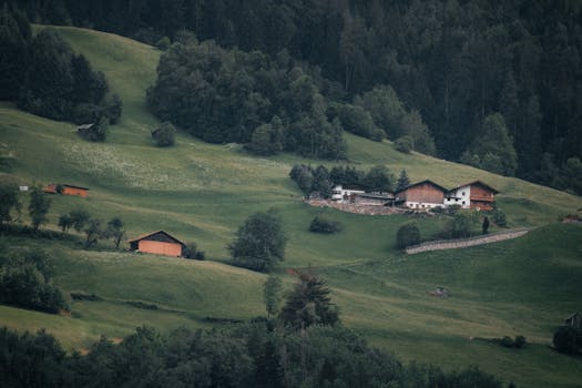 Idyllic alpine village view in Haiming, Tyrol showcasing lush greenery and rustic barns.