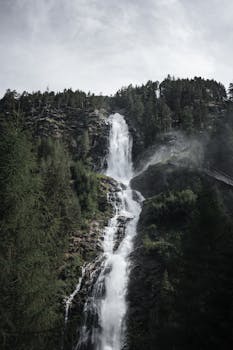 Stunning view of Stuibenfall, Austria's highest waterfall surrounded by lush forest in Tyrol.