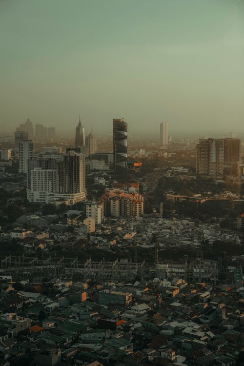 Free Explore the bustling Jakarta skyline with towering buildings and hazy dusk ambiance. Stock Photo