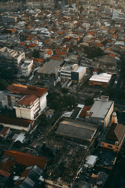 Aerial perspective of a densely populated urban area showcasing rooftops and buildings in an atmospheric setting.