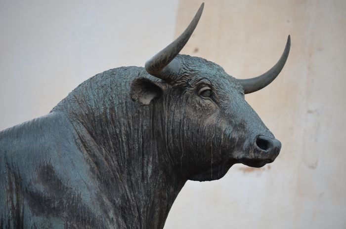 A cast bronze bull against a neutral ground — photo by Edu Jimenez on Pexels