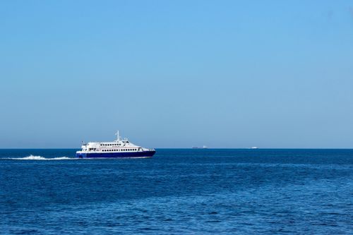 Free A modern ferry cruise across a serene blue sea under a clear sky, ideal for travel themes. Stock Photo