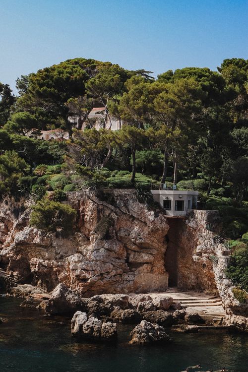 Free Picturesque coastal view with rocky formations and lush greenery in Antibes, France. Stock Photo