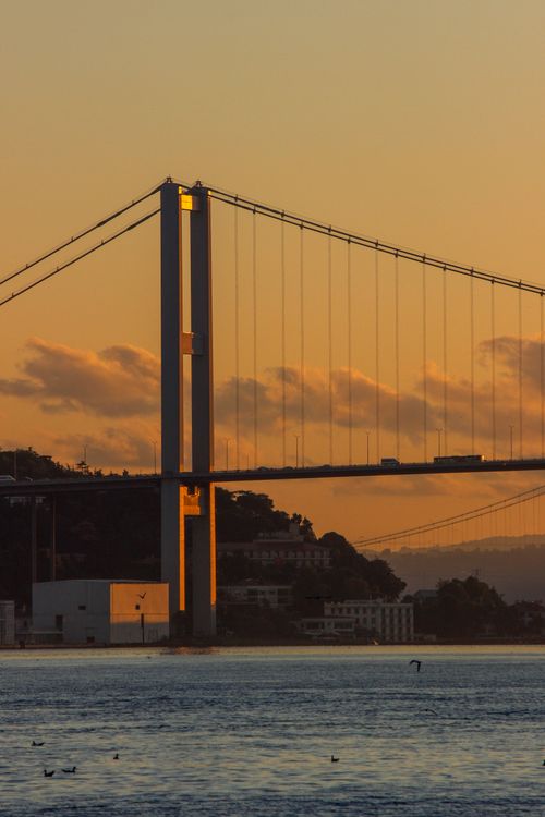 Free Golden hour view of the Bosphorus Bridge in Istanbul under a vibrant sunset sky. Stock Photo