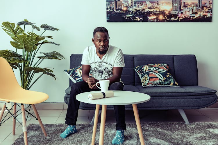 A Man In White T-shirt Sitting On Gray Couch