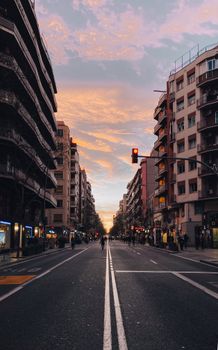 Urban street scene in L'Hospitalet de Llobregat, Spain at sunset with vibrant skies and city lights.