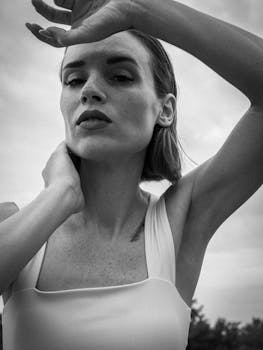 Stylish black and white portrait of a woman outdoors, showcasing elegance and poise.