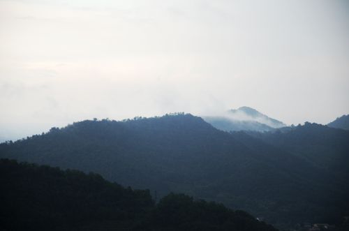 Free Serene landscape of misty mountain peaks under an overcast sky, creating a tranquil scenery. Stock Photo
