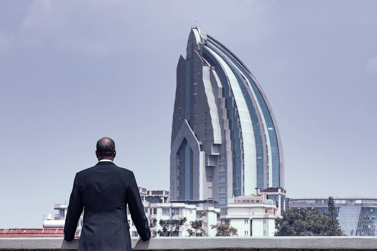 Man In Suit And Building Behind