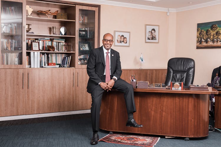 Man In Black Suit Sitting On His Office Desk