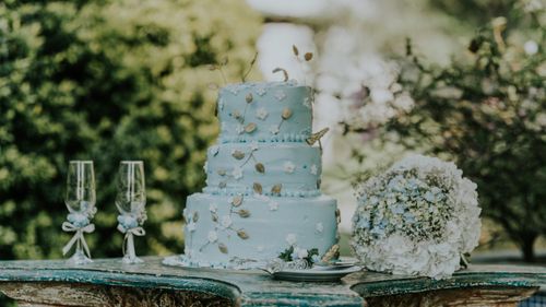 Free Beautiful blue wedding cake with floral decor and a bouquet, perfect for a romantic setting. Stock Photo