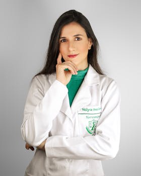 Portrait of a female healthcare professional in a white lab coat in a studio setting.