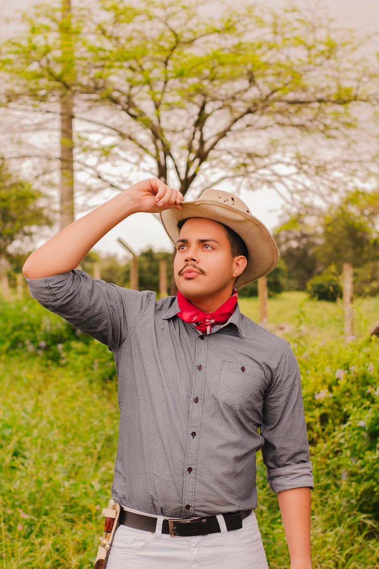 A Man In Gray Long Sleeve Shirt Wearing A Hat