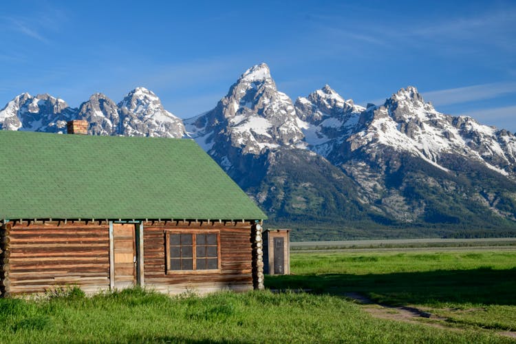 A Brown And Green Wooden House Near The Tetons In Wyoming, United States