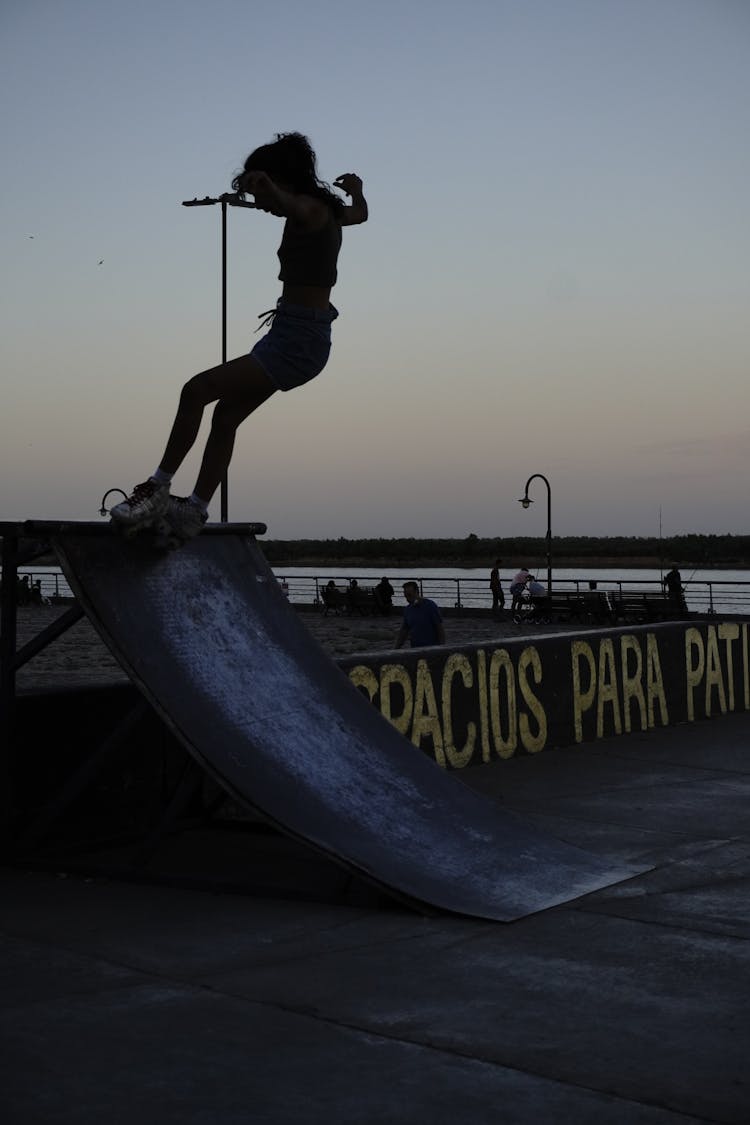 Silhouette Of A Person Skateboarding On A Ramp