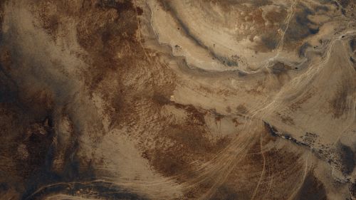 Free An aerial view showing the textured and barren desert landscape. Stock Photo