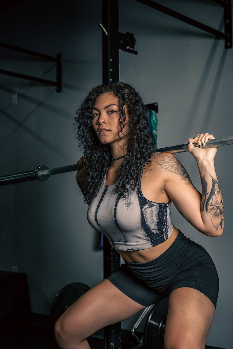 Woman In Sportswear Straining To Lift Weights In The Gym