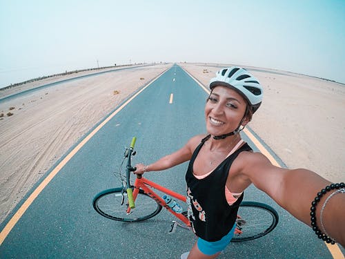 Mujer Sosteniendo Bicicleta En La Carretera Asfaltada