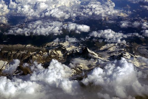 Free Breathtaking aerial view showcasing snow-capped mountains amidst clouds in Furna, Switzerland. Stock Photo