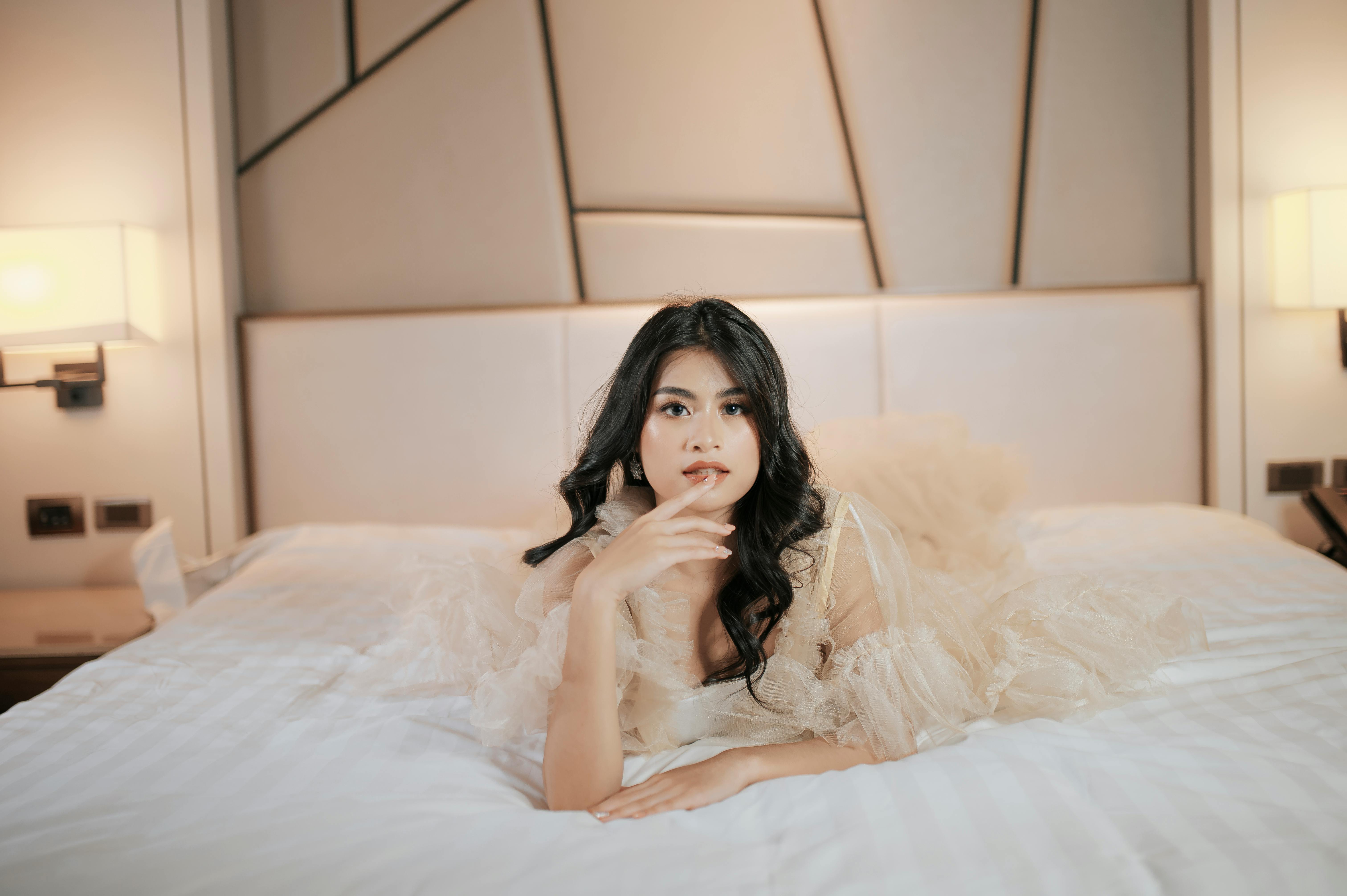 Photo of a Woman in Sleepwear Sitting on Her Bed · Free Stock Photo