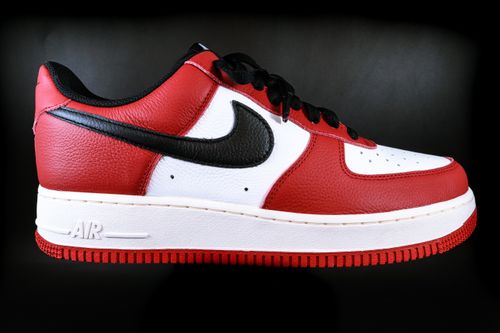 Free Close-up side view of a red and black sneaker with white sole, featuring leather texture on black background. Stock Photo
