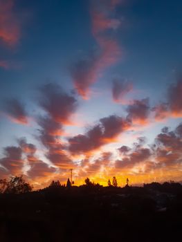 Captivating sunset with dramatic clouds and silhouette of nature.