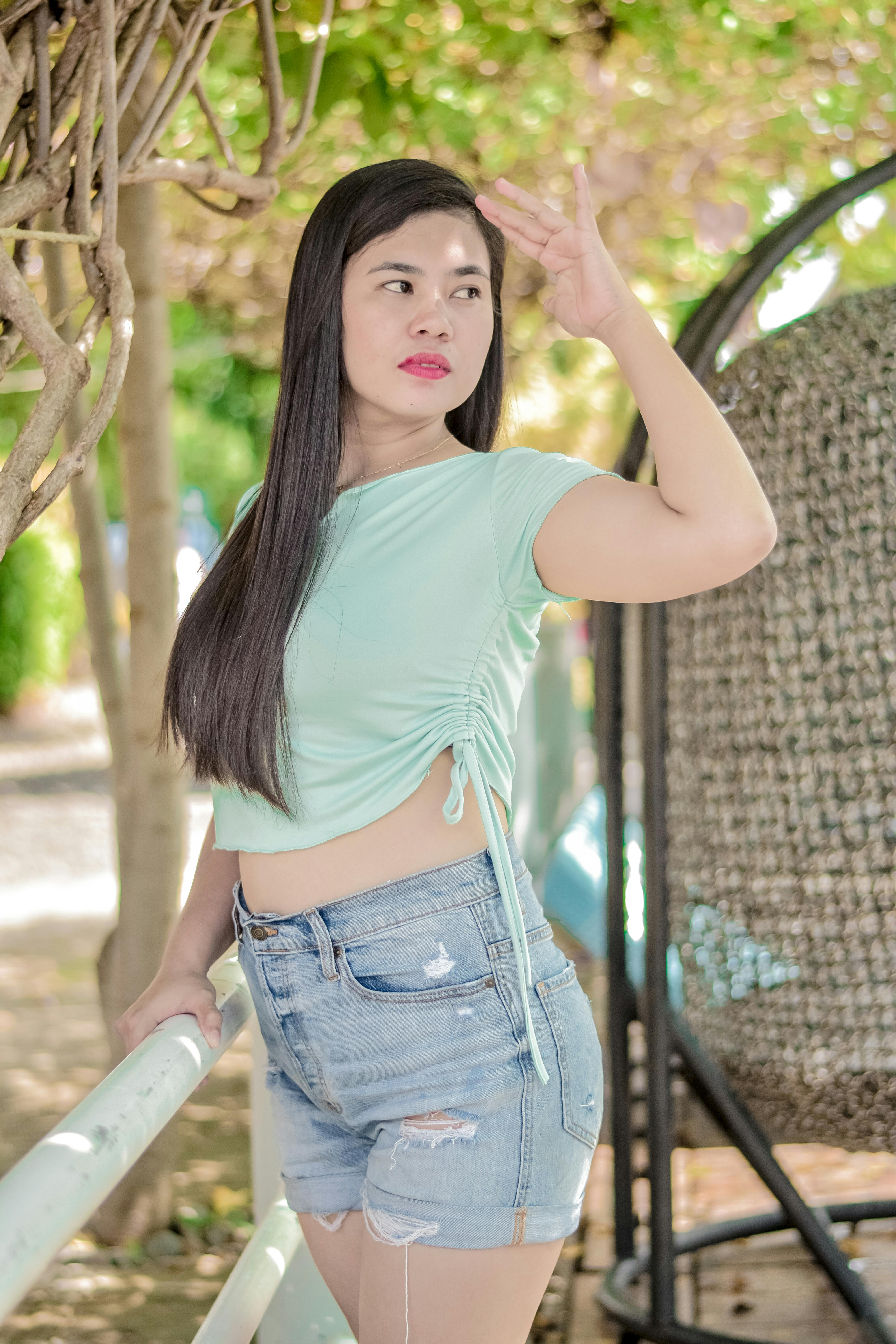 A Woman In A Crop Top And Denim Jeans Touching Her Hair · Free Stock Photo