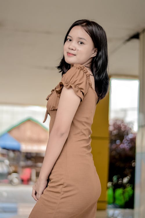 Woman in Brown Dress Looking Over Her Shoulder