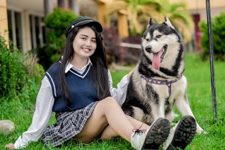 Woman Sitting With Husky Dog